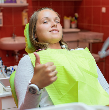  woman in dental chair giving thumbs up