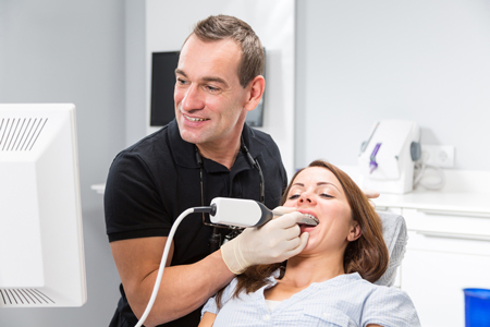 dentist scanning a patient's teeth with an iTero Intraoral scanner